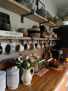 a kitchen counter with pots and pans hanging on the wall next to each other