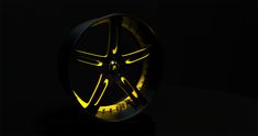 an illuminated wheel in the dark with yellow light on it's side and black background