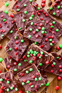 pieces of chocolate barkle with candy and sprinkles on a cutting board