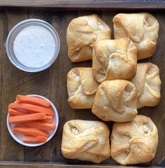 rolls, carrots and dip on a wooden tray