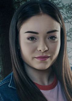 a woman with long brown hair wearing a jean jacket and red collared t - shirt