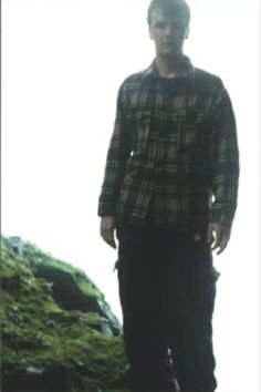 a man standing on top of a lush green hillside