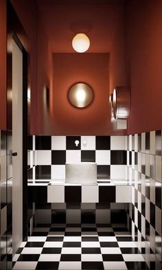 a black and white checkered floor in a bathroom with two lights on the ceiling