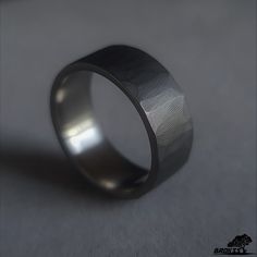 a wedding ring with a textured finish on the outside and inside, sitting on a plain surface