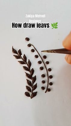 someone is drawing leaves on a piece of paper