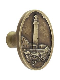 an antique style door knob with a lighthouse scene on the front and side of it