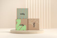 three boxes stacked on top of each other in front of a white wall with vertical stripes