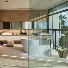 a bathroom with a large bathtub next to a sink and window overlooking the ocean