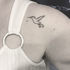 a woman with a small bird tattoo on her shoulder