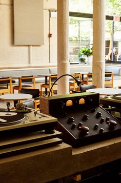 an old record player sitting on top of a table in a room filled with tables and chairs