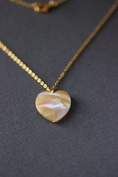 This delicate unique necklace was made of natural mother of pearl beige heart pendnat and high quality gold tone stainless steel chain with gold tone lobster claw. The chain is from lead & nickel free metal. Perfect jewelry for everyday wear and a great gift for someone special! The length of necklace is 45 cm or 17.7 inches. Other necklaces of my shop you can see here: https://www.etsy.com/shop/NaTavelli?section_id=14843046&ref=shopsection_leftnav_5 Thanks for a visit. White Minimalist Jewelry With Heart Charm, Minimalist White Heart Charm Jewelry, Shell Necklace With Round Pendant As A Gift, Gift Shell Necklace With Round Pendant, Mother Of Pearl Pendant Jewelry Gift, Mother Of Pearl Pendant Jewelry For Gifts, Minimalist Pearl Heart Pendant Jewelry, Gold Necklaces With Gemstone And Mother Of Pearl, Minimalist Heart-shaped Pearl Pendant Jewelry