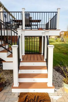 a deck with stairs and railings in front of a house