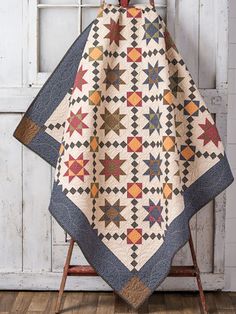 a quilted blanket sitting on top of a wooden chair next to a white door