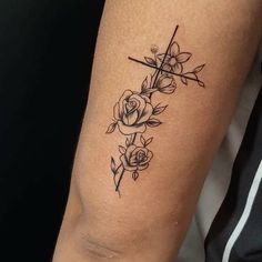 a woman's arm with roses on it and a cross in the middle,