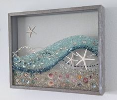 an ocean scene with starfish and seashells is displayed in a shadow box