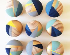 six wooden knobs with different colors and designs on them, all in the same pattern