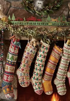 christmas stockings hanging from a mantel in front of a fireplace