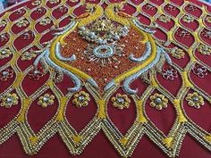 an elaborately designed bed spread with gold and red trimmings on top of it