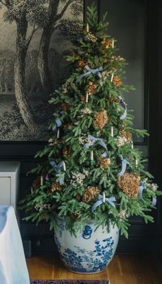 a decorated christmas tree in a blue and white vase