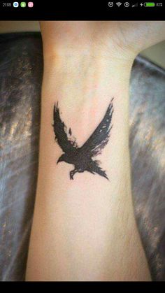 a black bird tattoo on the wrist