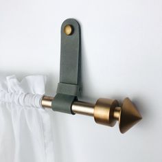 the curtain rod is attached to the wall with two brass handles and a white drape