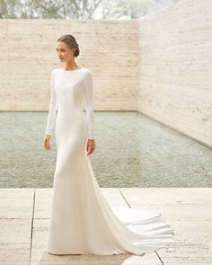 a woman in a white wedding dress standing next to a pool