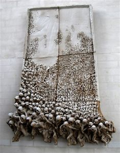 a group of skulls sitting on top of a white wall