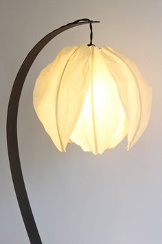 a lamp that is sitting on top of a wooden stand with a white light in it