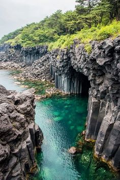 the water is crystal blue and green in this cave near an island with cliffs on both sides