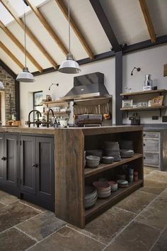 an open kitchen with lots of plates and bowls on the island in front of it