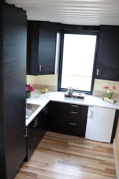 a kitchen with black cabinets and white counter tops