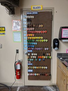 a wall mounted bulletin board with many different colored paper hearts attached to it in a garage