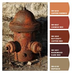 an old rusted fire hydrant sitting in front of a rock wall with color swatches