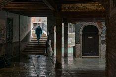 a man walking down some stairs in an alley way with graffiti on the walls and floor