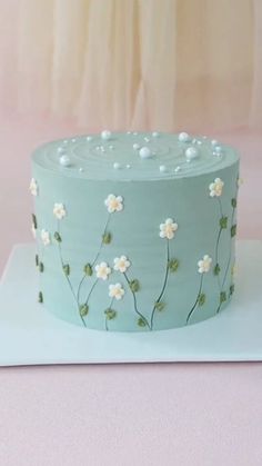 a blue cake with white flowers on it