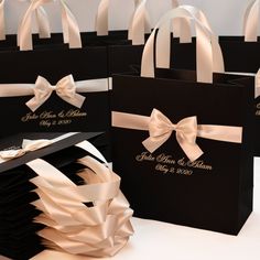 four black and white bags with bows on the front, two are for wedding guests