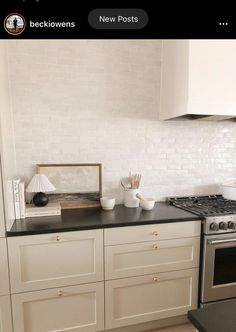 a kitchen with white cabinets and black counter tops is featured on the instagram page