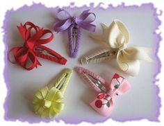 four small hair clips with bows on them