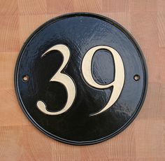 a black and white house number sign on a wooden floor