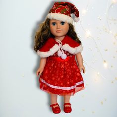 a doll wearing a red dress and santa hat