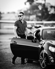 a man standing next to a sports car