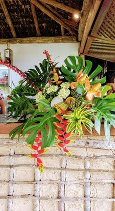 a bunch of plants sitting on top of a brick wall in front of a woman