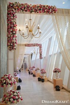 an aisle decorated with flowers and chandelier