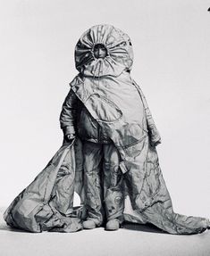 a black and white photo of a man in a suit made out of plastic bags