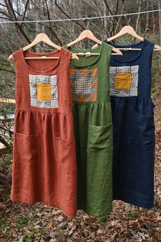 three dresses hanging on a clothes line in the woods