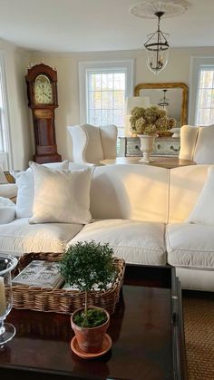 a living room filled with furniture and a clock on the wall next to a window