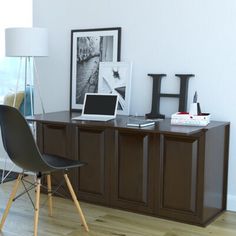 a desk with two chairs and pictures on the wall