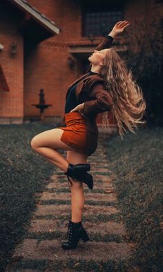 a woman with long hair is dancing outside