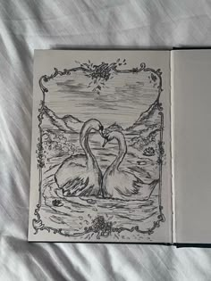 an open book with two swans on it