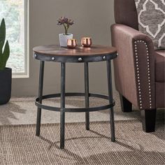 a living room with a chair, table and potted plant on the carpeted floor